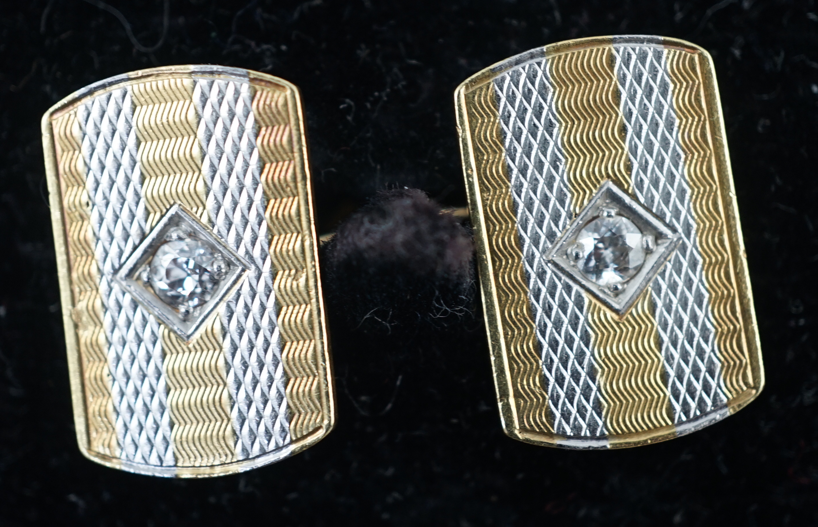 A pair of mid 20th century two colour 18ct gold and single stone diamond set cufflinks